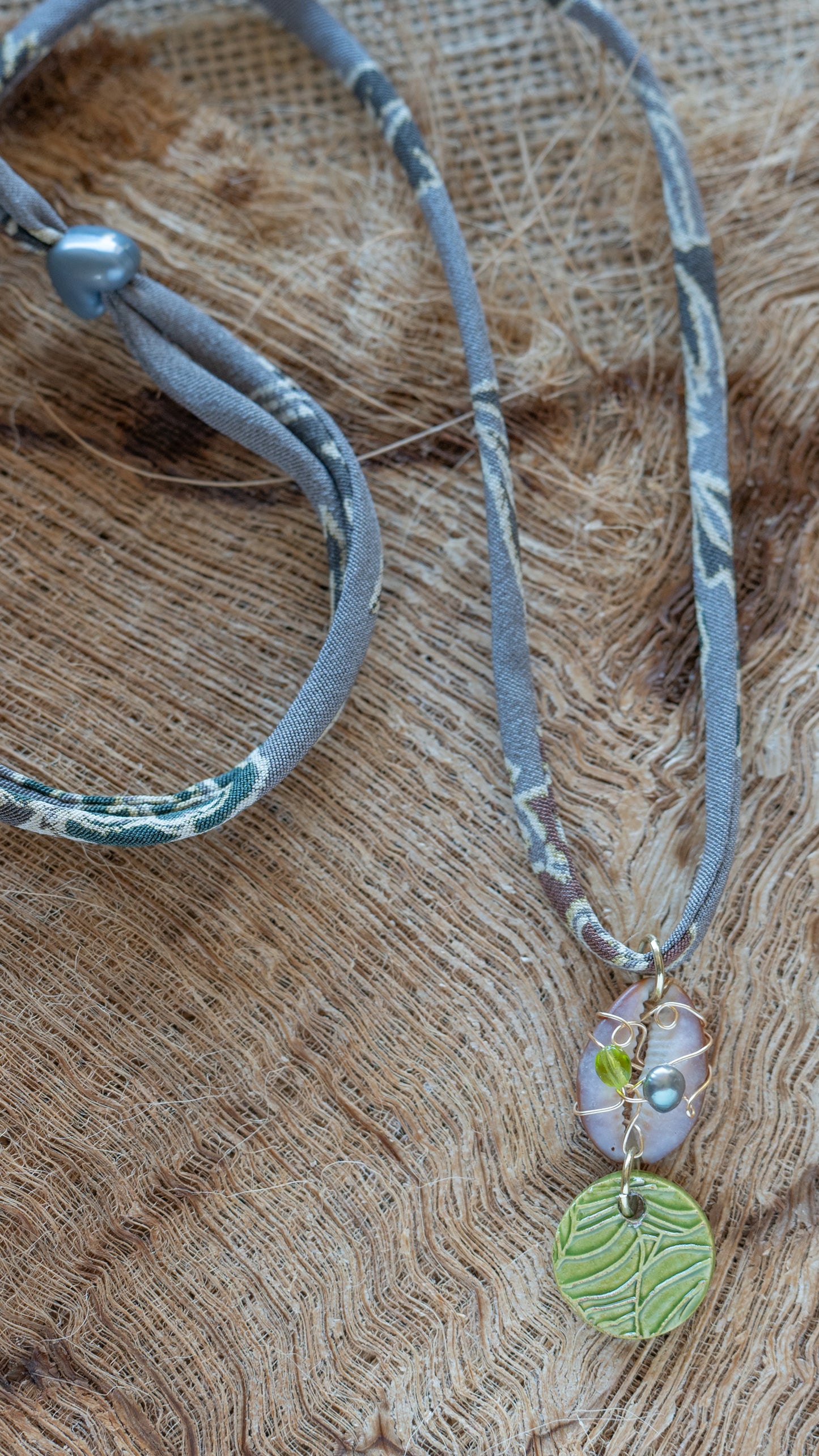 NKL-MON03GRN: Green Monstera Leaf Ceramic Necklace with Wire wrapped Cowrie Shell and Adjustable Floral Kimono Cord – Green Glaze