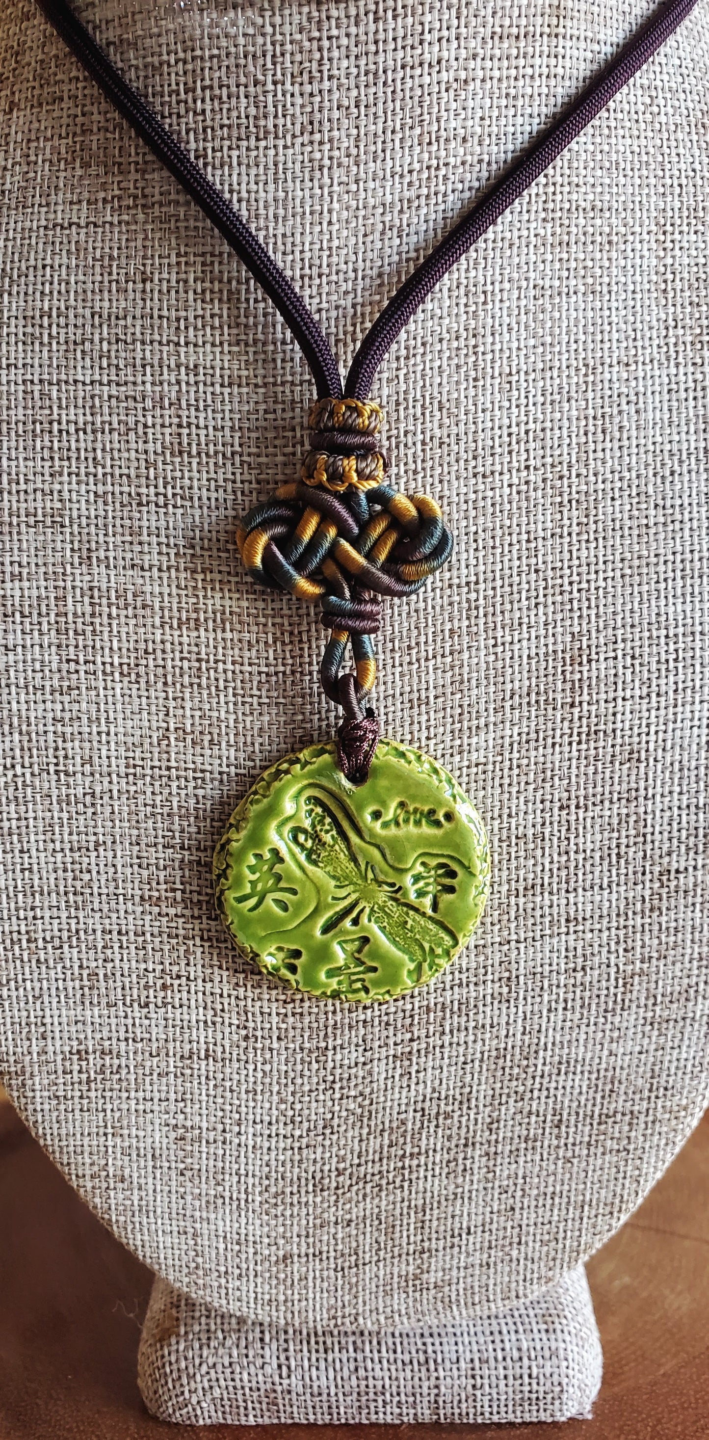 NKL-DRG01GRN: Dragonfly, Courage in Kanji and Love Ceramic Necklace with Celtic weaved cord - Green glaze