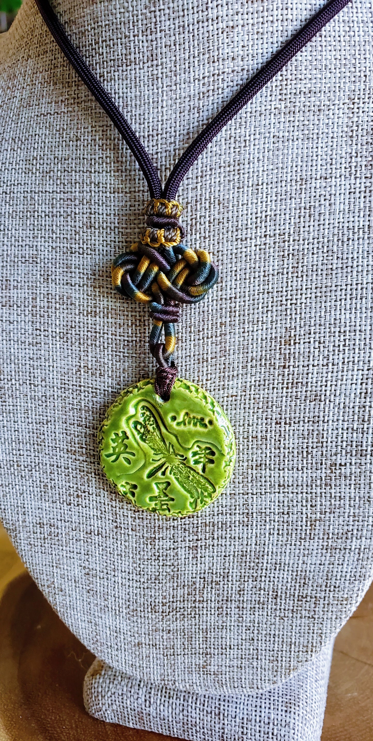 NKL-DRG01GRN: Dragonfly, Courage in Kanji and Love Ceramic Necklace with Celtic weaved cord - Green glaze