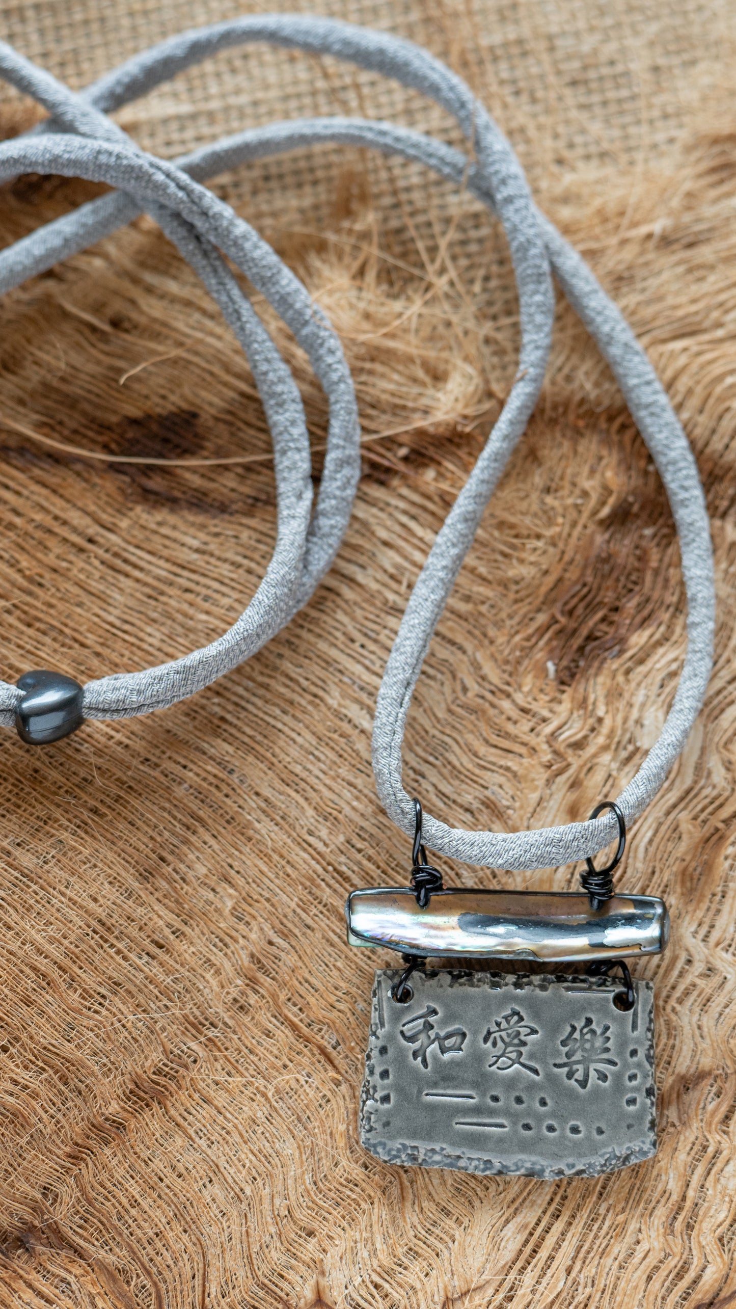 NKL-PLH02GRY: Peace, Love, Happiness in Kanji Ceramic Necklace with Abalone and Grey Repurposed Silk Kimono Cord