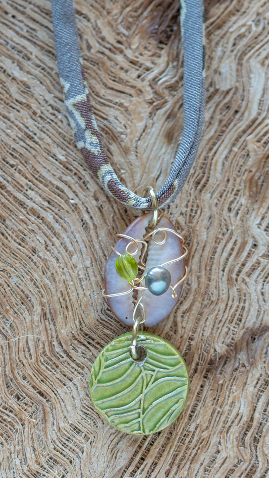 NKL-MON03GRN: Green Monstera Leaf Ceramic Necklace with Wire wrapped Cowrie Shell and Adjustable Floral Kimono Cord – Green Glaze