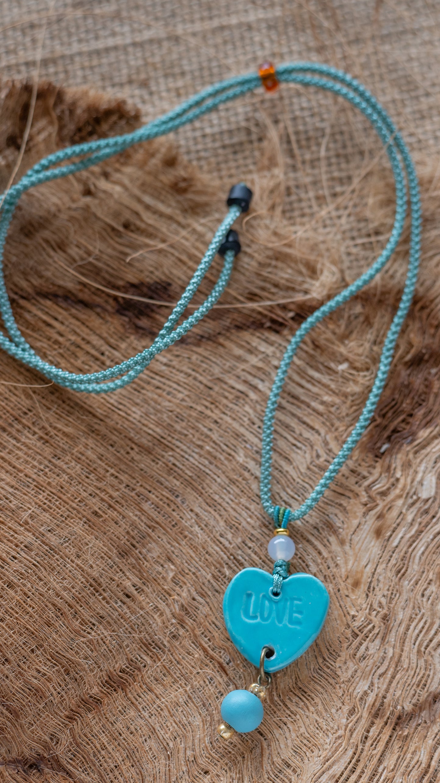 NKL-LOV01AQA: Love Heart Shaped Aqua Ceramic Necklace – Braided Silk Cord