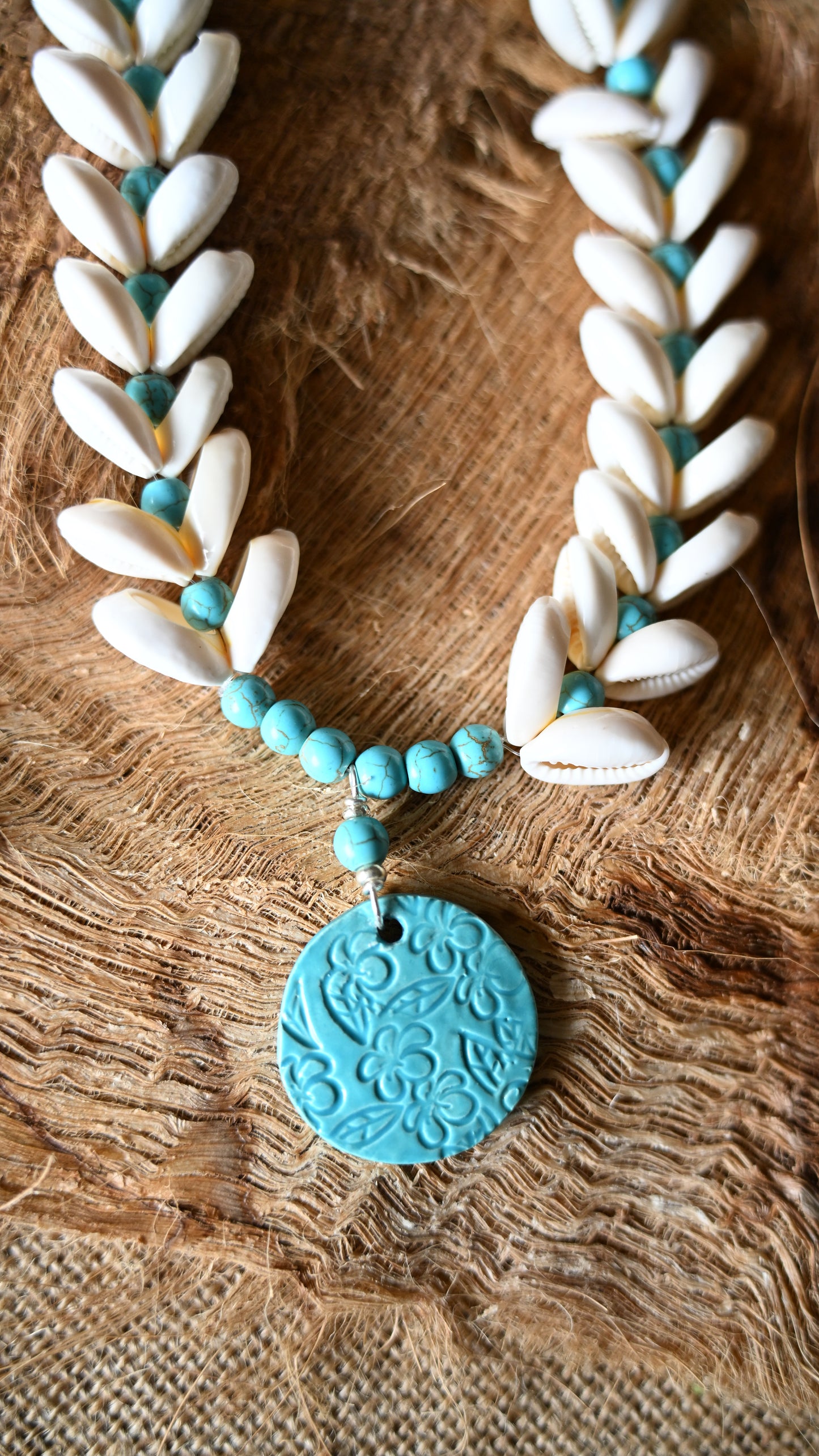 Handcrafted Ceramic necklace with Plumeria design on the pendant, glazed with Aqua glaze, hand-strung with Cowrie Shells and Turquoise Beads necklace