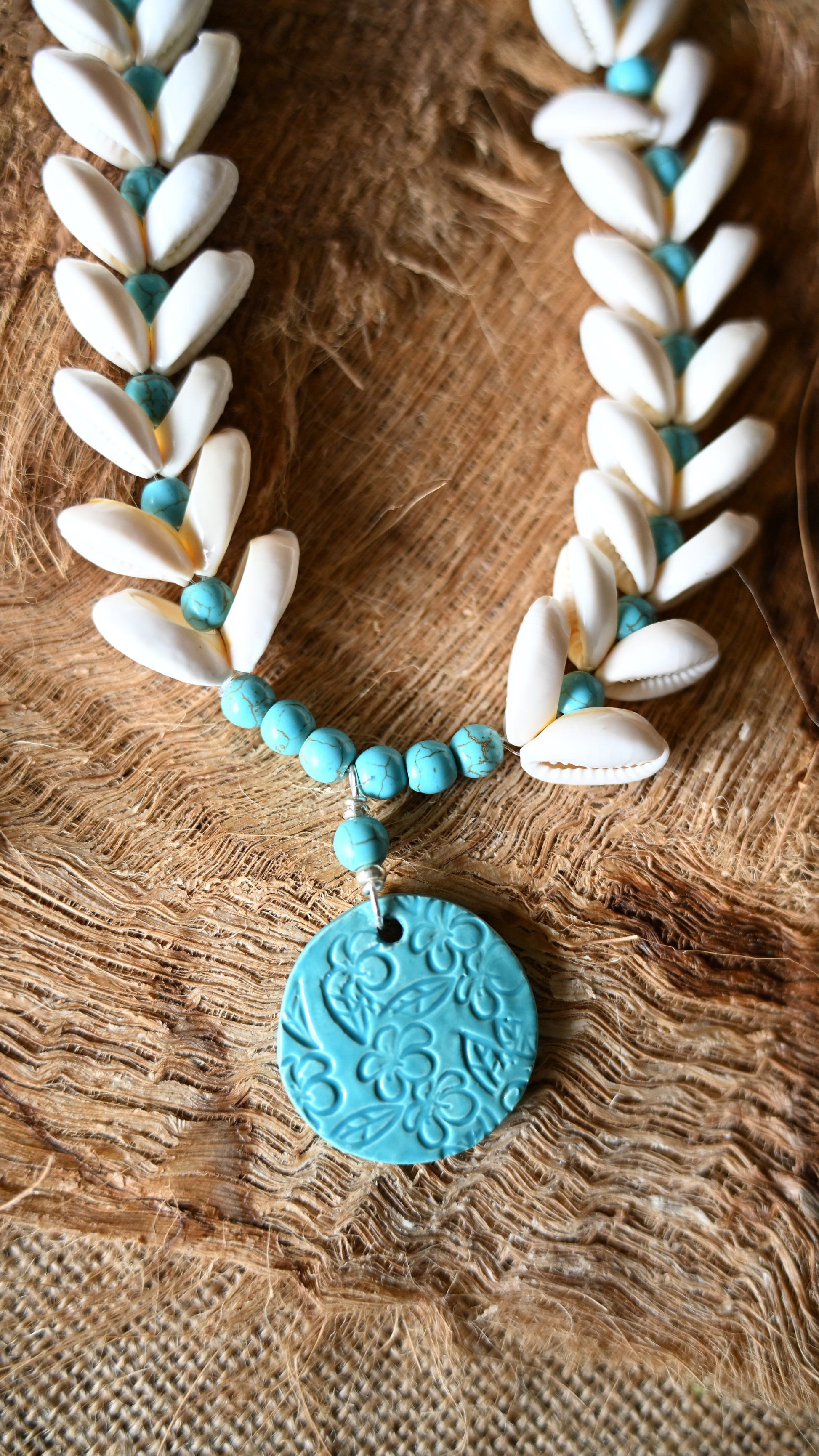 Handcrafted Ceramic necklace with Plumeria design on the pendant, glazed with Aqua glaze, hand-strung with Cowrie Shells and Turquoise Beads necklace